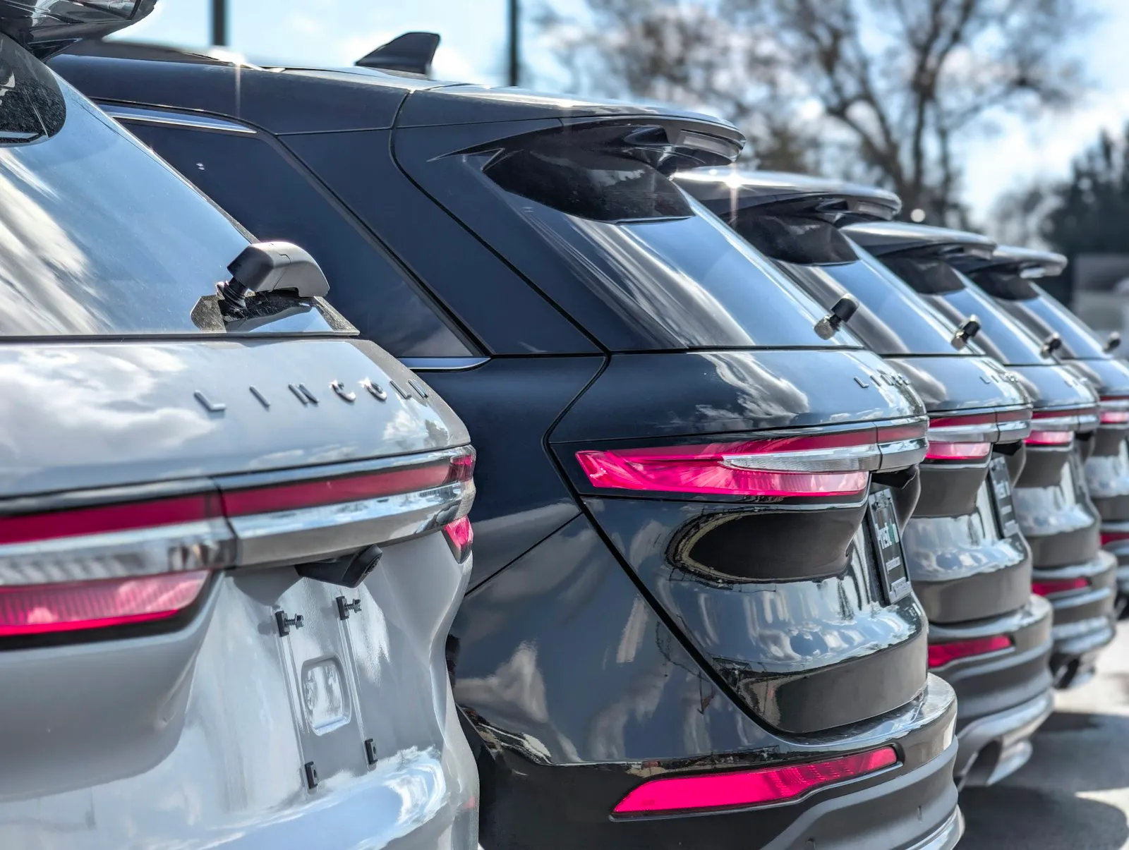 A row of new Lincoln SUVs at a franchise dealership
