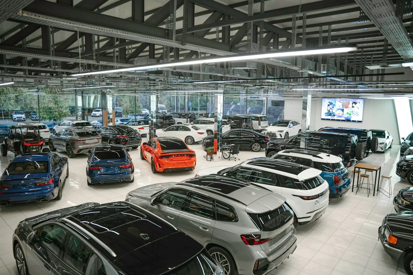 A busy dealership showroom floor with a mix of new and pre-owned vehicles